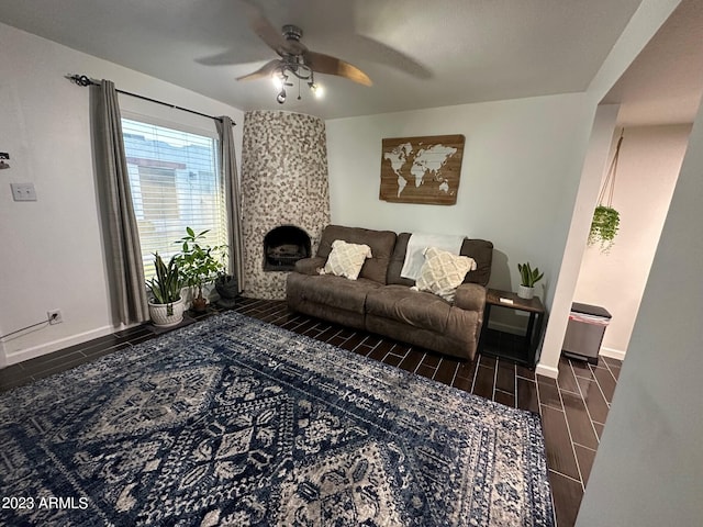 living room with ceiling fan and a fireplace