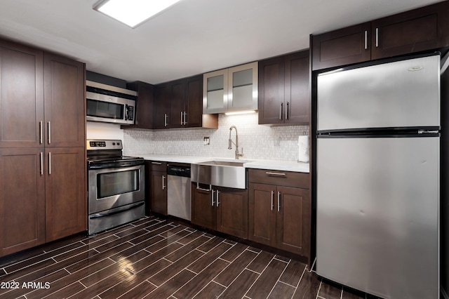 kitchen with appliances with stainless steel finishes, dark brown cabinetry, and sink