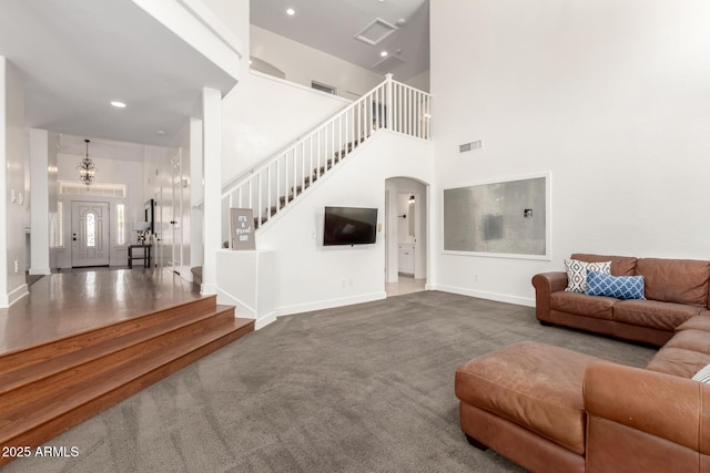 3772 E Leah Ln, Gilbert, AZ 85234 - carpeted living room featuring stairway, a towering ceiling, arched walkways, a chandelier, and recessed lighting