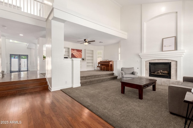 3772 E Leah Ln, Gilbert, AZ 85234 - living room with built in shelves, a tiled fireplace, a towering ceiling, hardwood / wood-style floors, and a ceiling fan