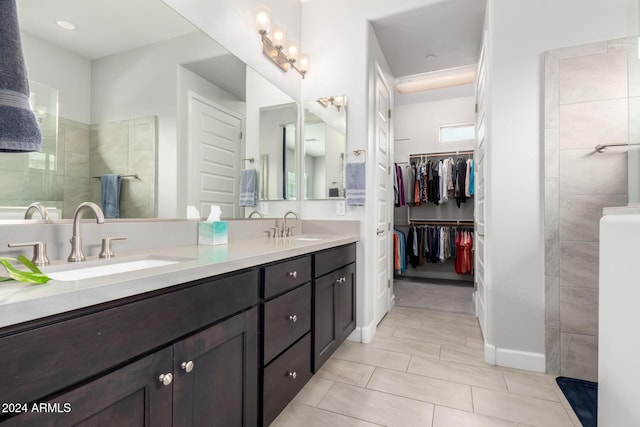 bathroom with vanity and a tile shower