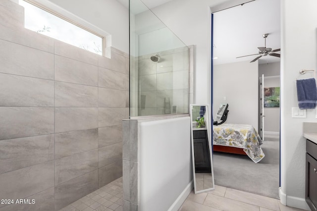 bathroom featuring a tile shower, vanity, tile patterned floors, and ceiling fan