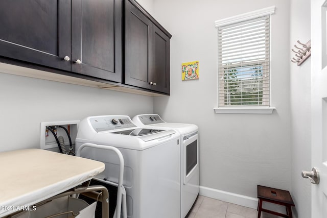 laundry area with washer and dryer, cabinets, and light tile patterned floors