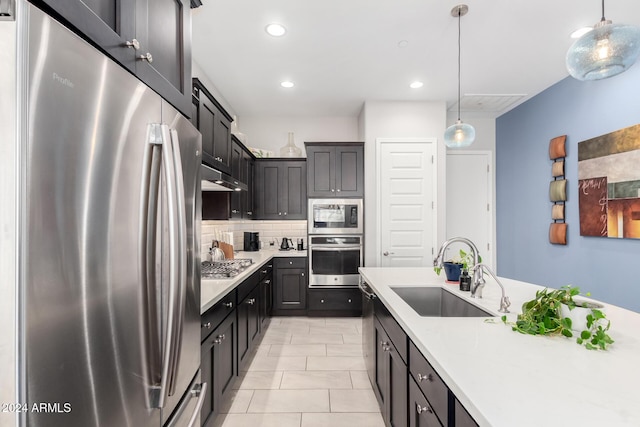 kitchen with sink, pendant lighting, decorative backsplash, light tile patterned floors, and appliances with stainless steel finishes