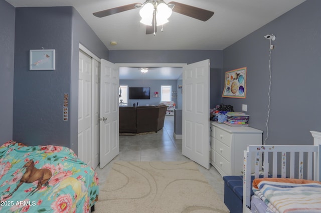 bedroom with light tile patterned flooring, ceiling fan, and a closet