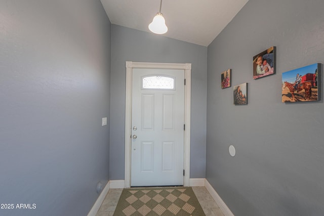 doorway featuring light tile patterned flooring and lofted ceiling