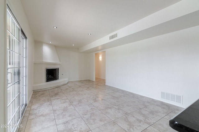 unfurnished living room featuring a fireplace and light tile patterned floors