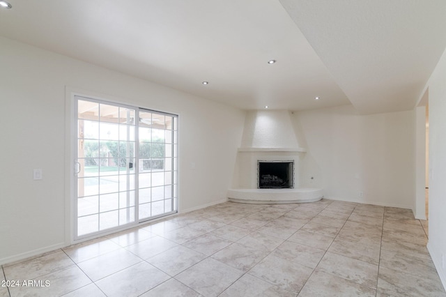 unfurnished living room featuring a large fireplace and light tile patterned floors