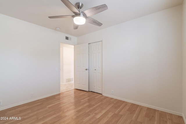 unfurnished bedroom with ceiling fan, a closet, and light hardwood / wood-style flooring