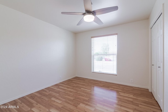 unfurnished bedroom featuring a closet, light hardwood / wood-style flooring, and ceiling fan