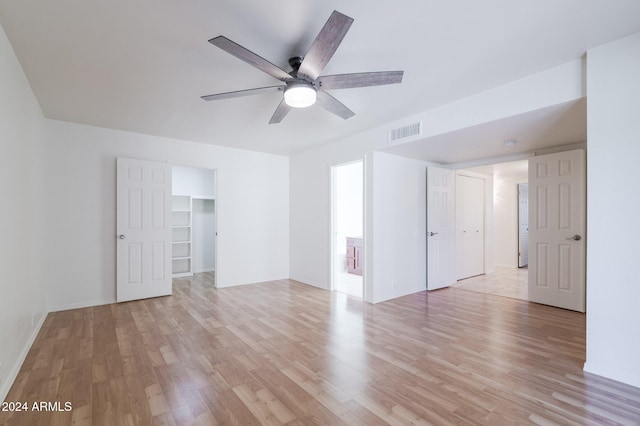 empty room with ceiling fan and light hardwood / wood-style floors