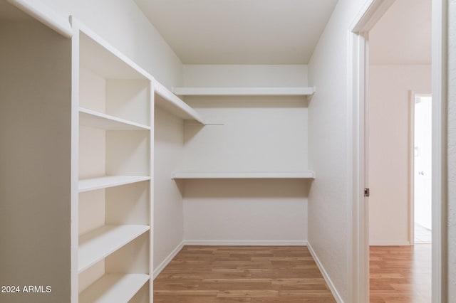 walk in closet with hardwood / wood-style flooring