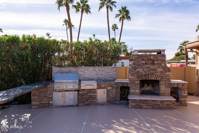 view of patio / terrace featuring area for grilling, exterior kitchen, and an outdoor stone fireplace