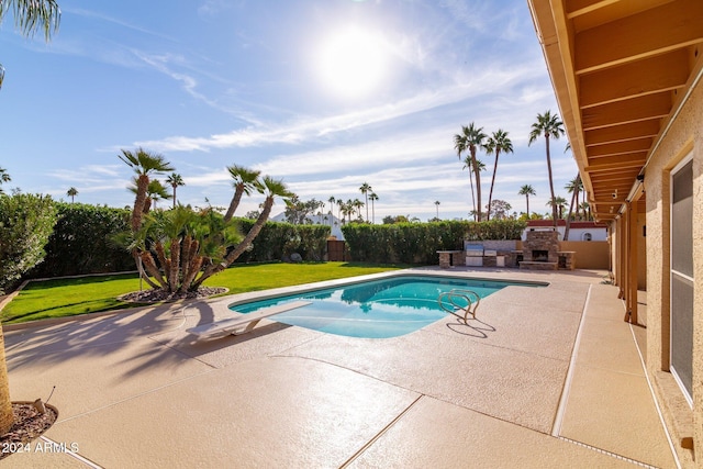 view of swimming pool featuring a diving board, a patio area, a yard, and an outdoor fireplace