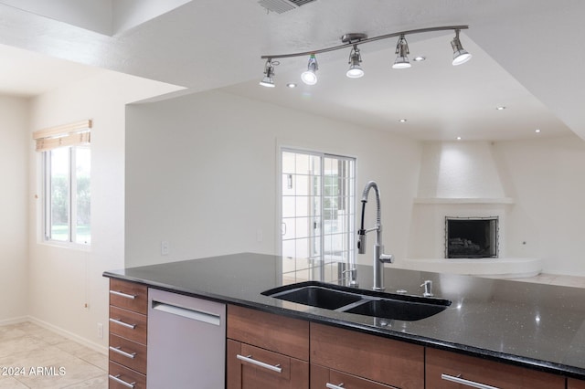 kitchen featuring dishwasher, light tile patterned floors, sink, and dark stone counters