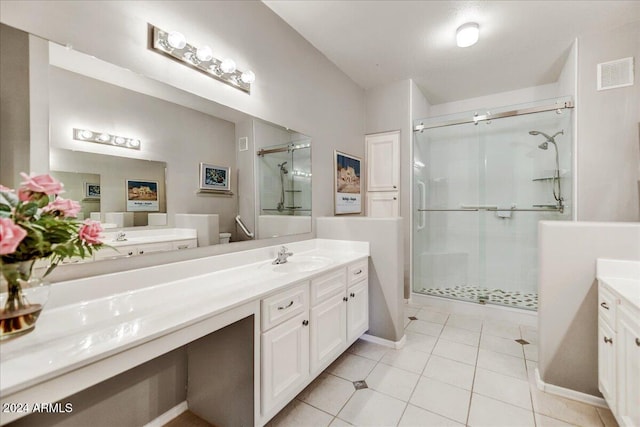 bathroom with vanity, a shower with shower door, and tile patterned floors