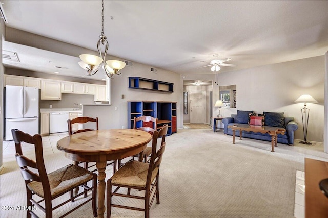 dining area with light carpet, sink, and ceiling fan with notable chandelier