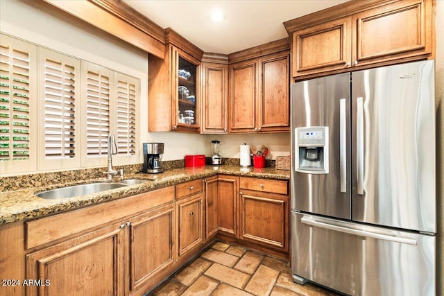 kitchen with sink, dark stone counters, and stainless steel fridge