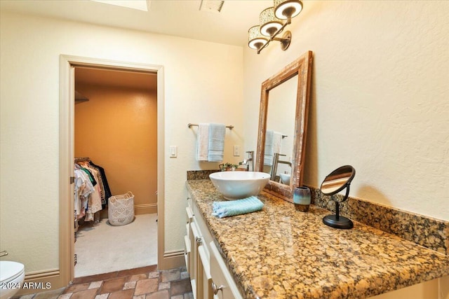 8638 E Paraiso Dr, Scottsdale, AZ 85255 - bathroom featuring toilet, visible vents, stone finish floor, and vanity