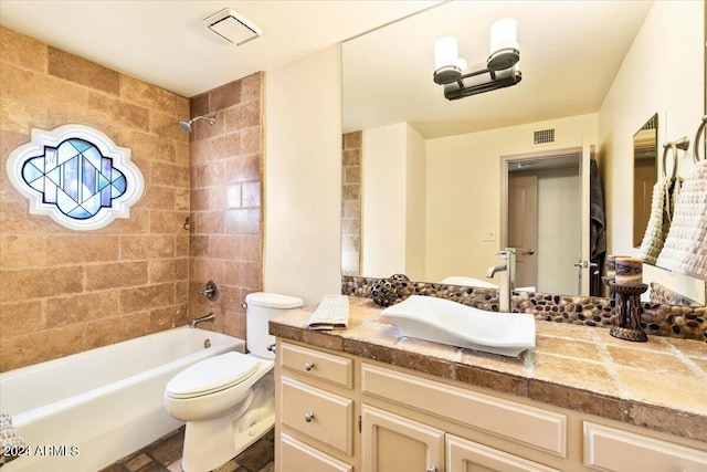 full bathroom featuring tiled shower / bath, vanity, and toilet