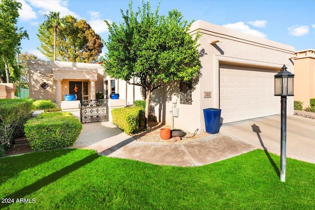 pueblo-style house with a front yard and a garage