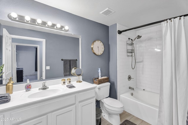 full bathroom featuring shower / bath combo, vanity, and toilet