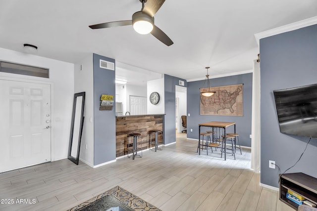 living room featuring crown molding and ceiling fan