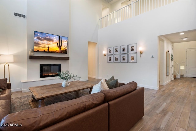 5661 S Dante, Mesa, AZ 85212 - living room with a high ceiling, wood finished floors, a glass covered fireplace, and baseboards
