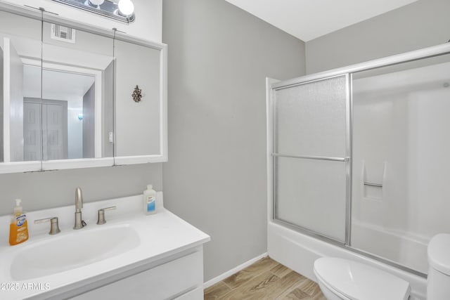 full bathroom with vanity, toilet, and bath / shower combo with glass door