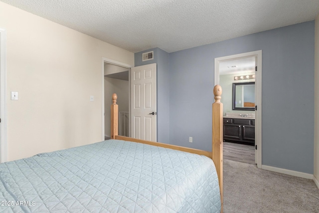 unfurnished bedroom featuring connected bathroom, light colored carpet, and a textured ceiling