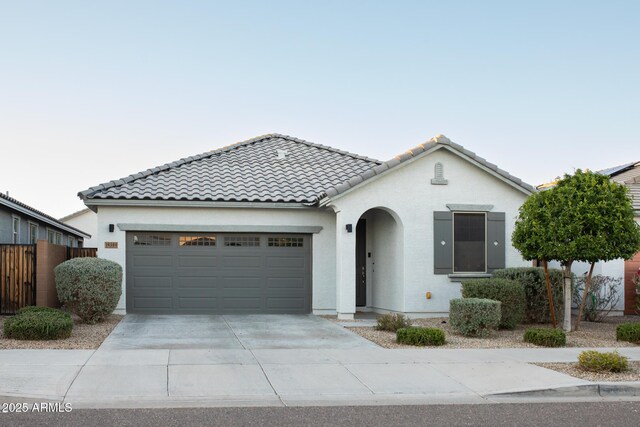 14344 W Hackamore Dr, Surprise, AZ 85387 - mediterranean / spanish-style house with an attached garage, driveway, a tiled roof, stucco siding, and fence