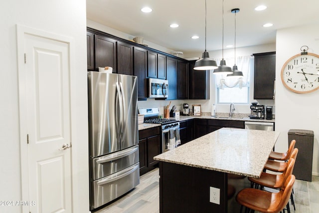 14344 W Hackamore Dr, Surprise, AZ 85387 - kitchen featuring stainless steel appliances, a sink, a kitchen breakfast bar, recessed lighting, and light stone countertops