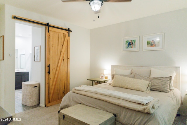 14344 W Hackamore Dr, Surprise, AZ 85387 - bedroom featuring a barn door, ensuite bathroom, carpet flooring, and a ceiling fan