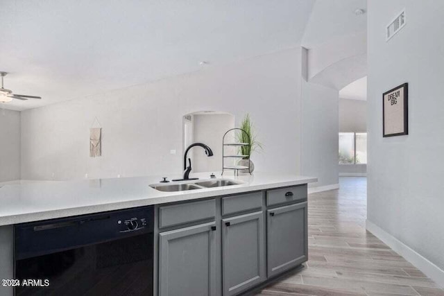 kitchen with gray cabinetry, sink, light hardwood / wood-style flooring, ceiling fan, and black dishwasher