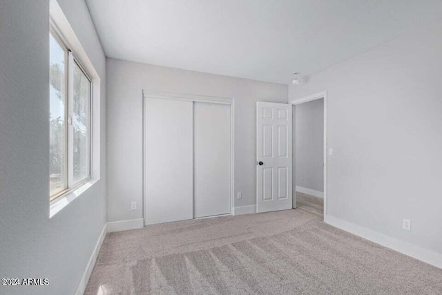 unfurnished bedroom with carpet and a closet