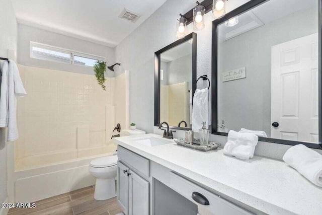 full bathroom featuring hardwood / wood-style flooring, vanity, toilet, and washtub / shower combination