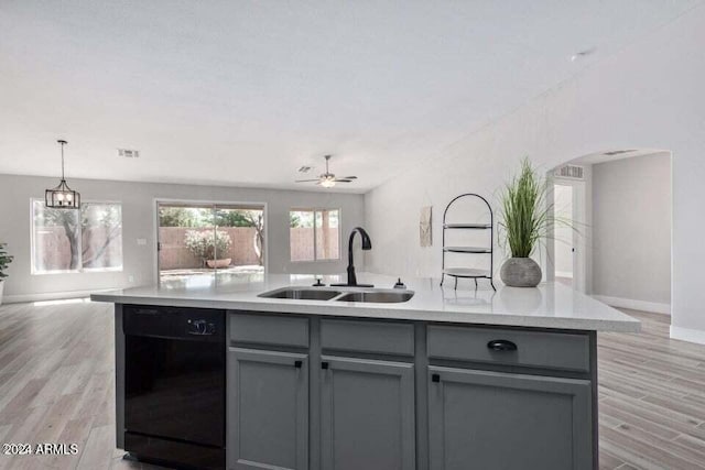 kitchen with ceiling fan, sink, a center island with sink, light hardwood / wood-style flooring, and black dishwasher