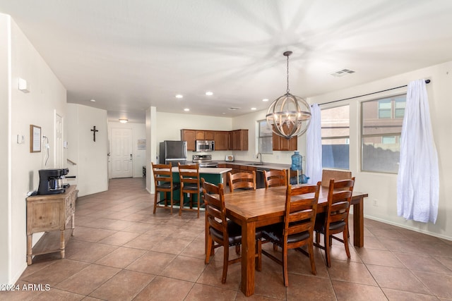 tiled dining area with a chandelier and sink