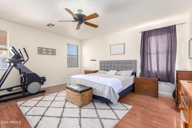 bedroom featuring multiple windows, hardwood / wood-style floors, and ceiling fan