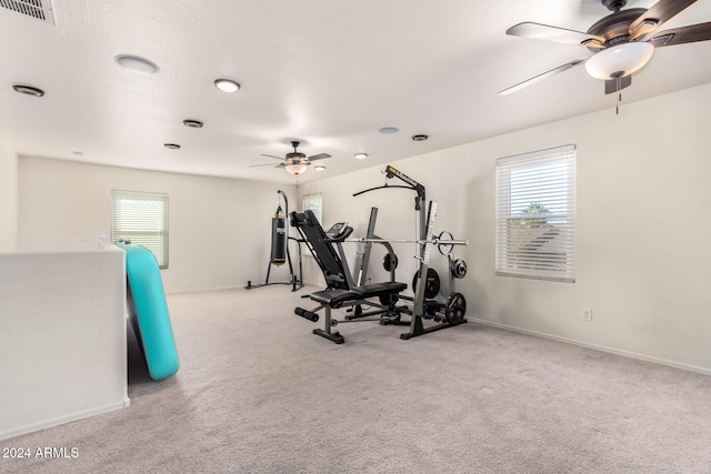 exercise area featuring ceiling fan and light colored carpet