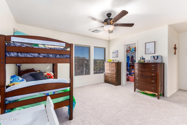 bedroom with a closet, ceiling fan, and light colored carpet