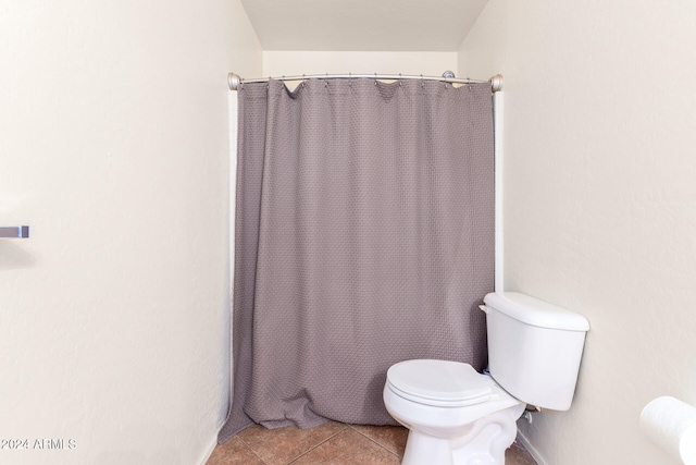 bathroom featuring tile patterned flooring, toilet, and walk in shower