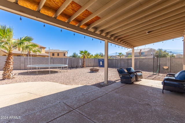 view of patio / terrace featuring a trampoline and an outdoor fire pit