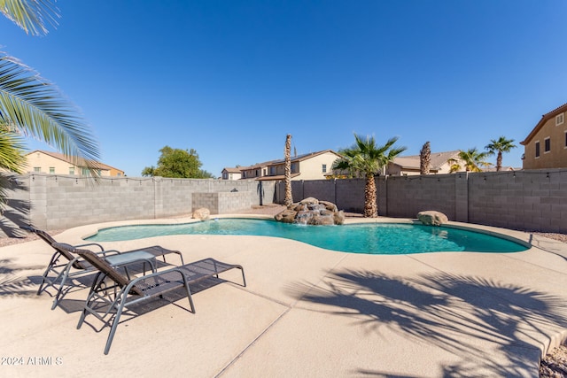 view of swimming pool with pool water feature and a patio area