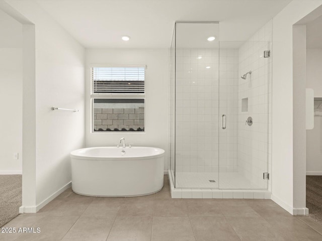 bathroom with a stall shower, baseboards, a soaking tub, tile patterned flooring, and recessed lighting