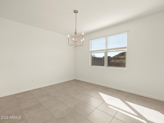 unfurnished room with a chandelier, baseboards, and light tile patterned flooring