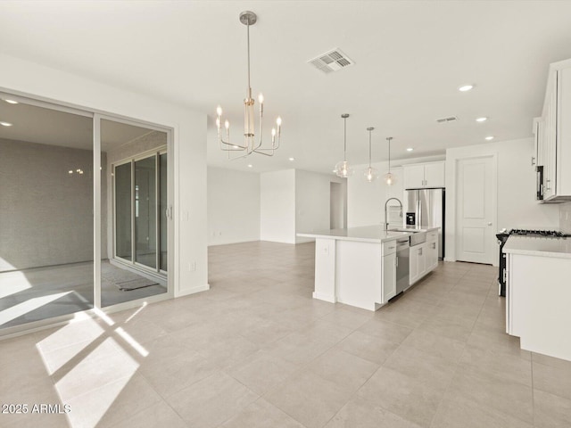 kitchen featuring stainless steel appliances, a sink, recessed lighting, light countertops, and a chandelier