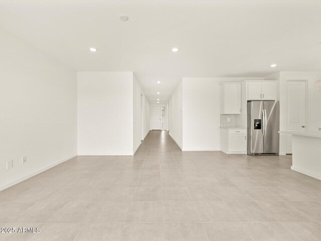unfurnished living room featuring recessed lighting and baseboards