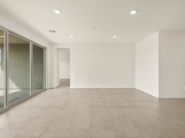 empty room with recessed lighting, light tile patterned floors, and baseboards