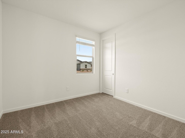 unfurnished room with carpet flooring and baseboards